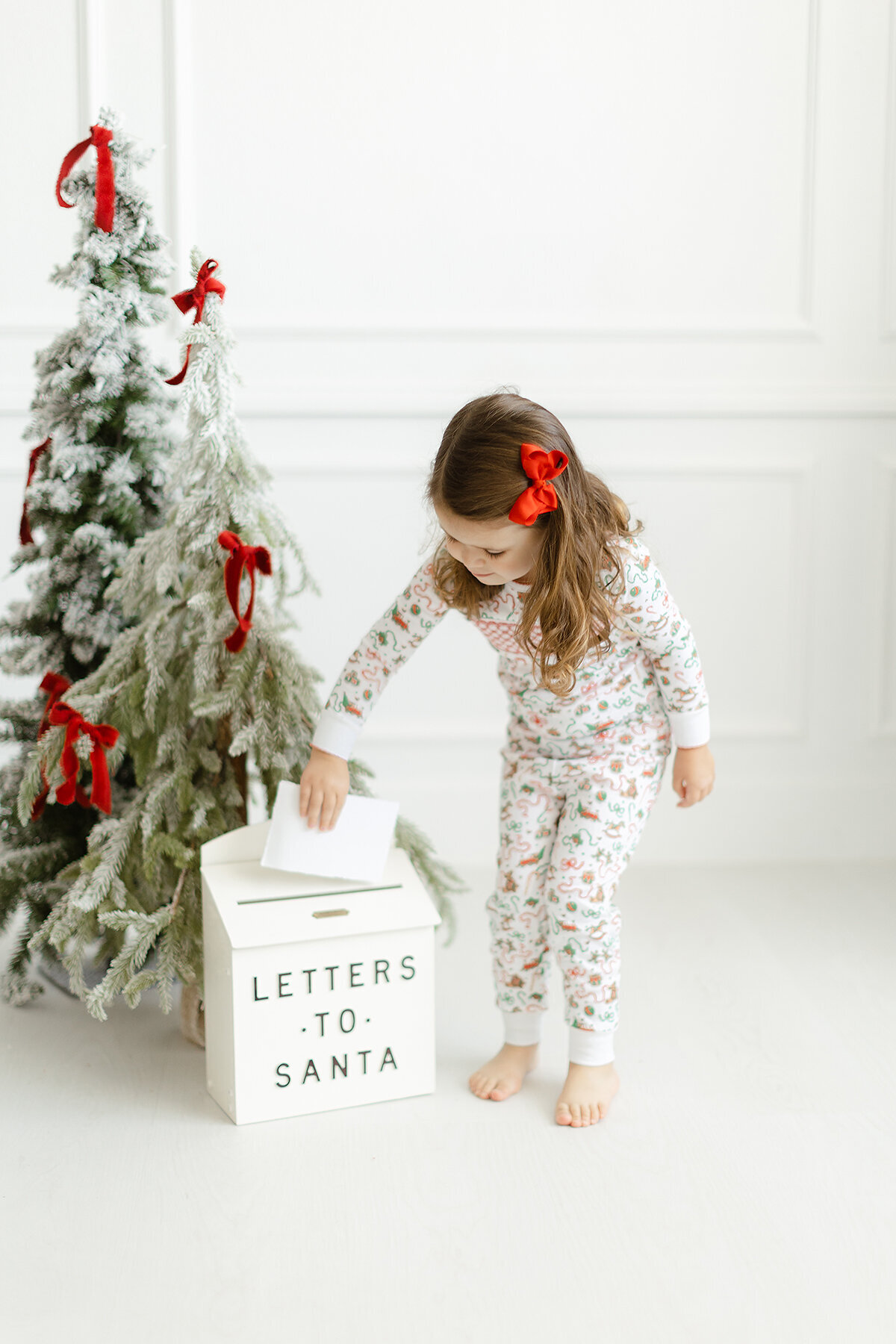 A little girl putting a letter in a "Letters to Santa" box - Dondolo branding session
