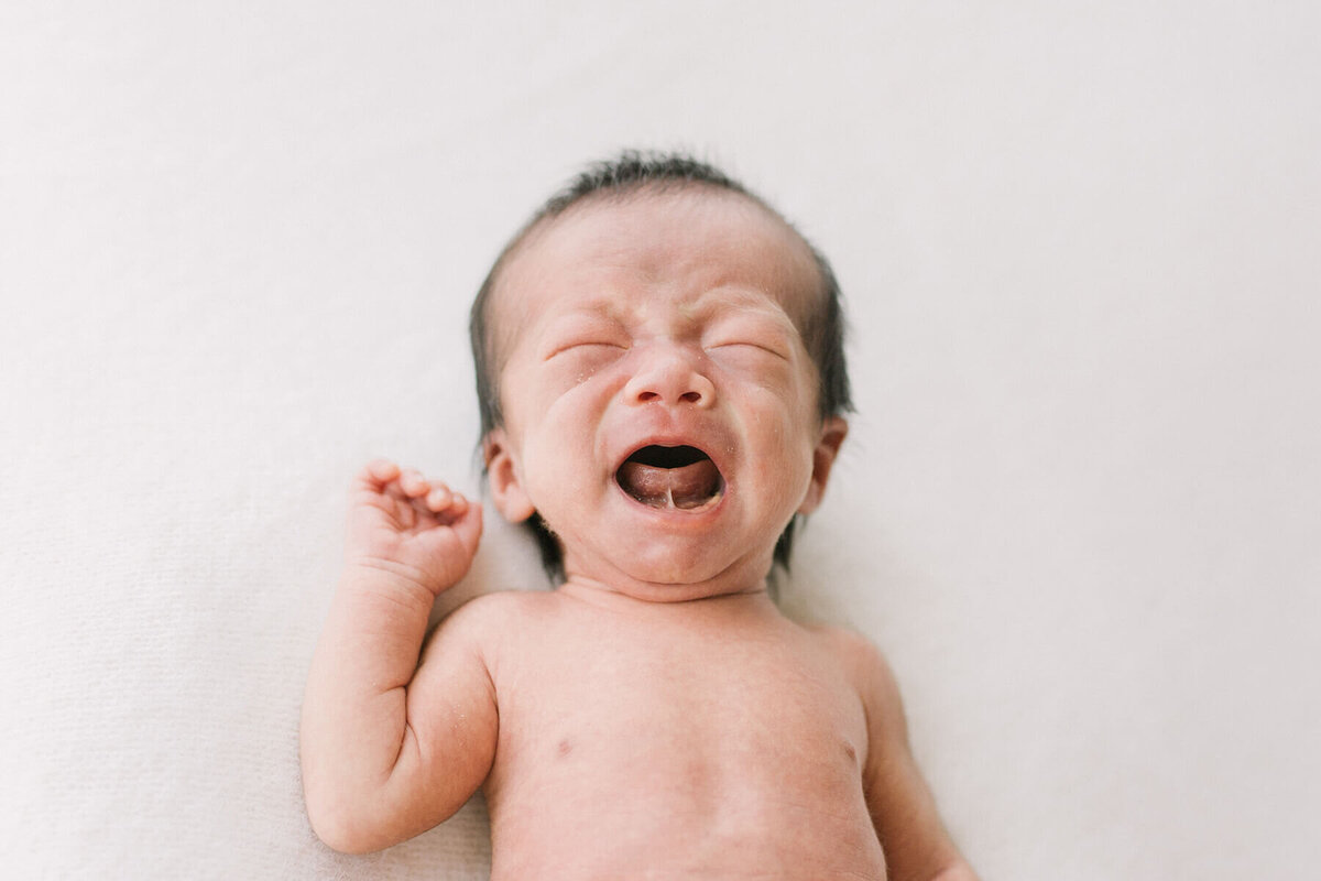 大泣きしている新生児の赤ちゃんのかわいらしいニューボーンフォト