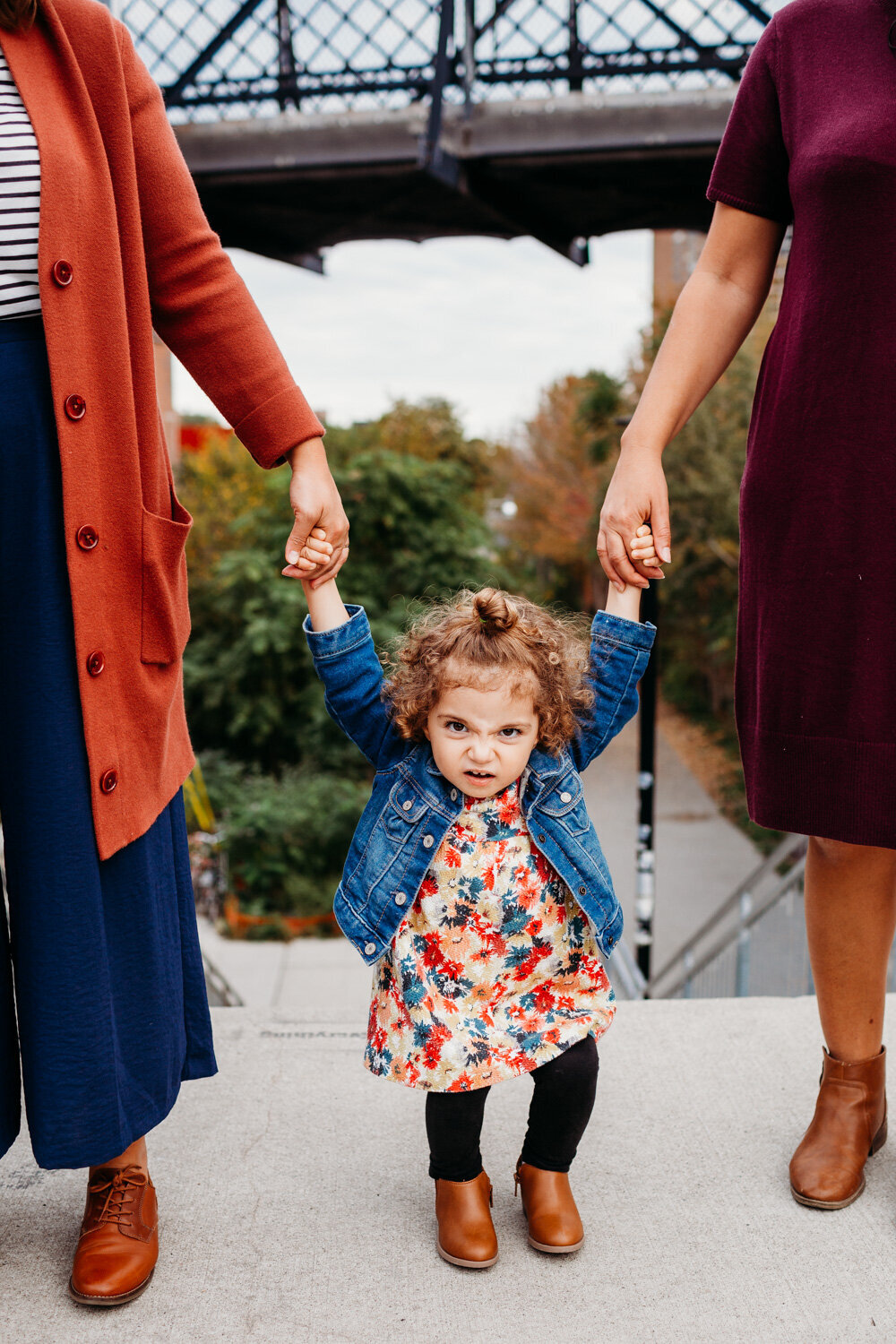 toddler girl making grumpy face during her family photography session with two moms