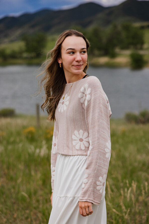 Girl looks over her shoulder with a lake behind her in Denver, Colorado.