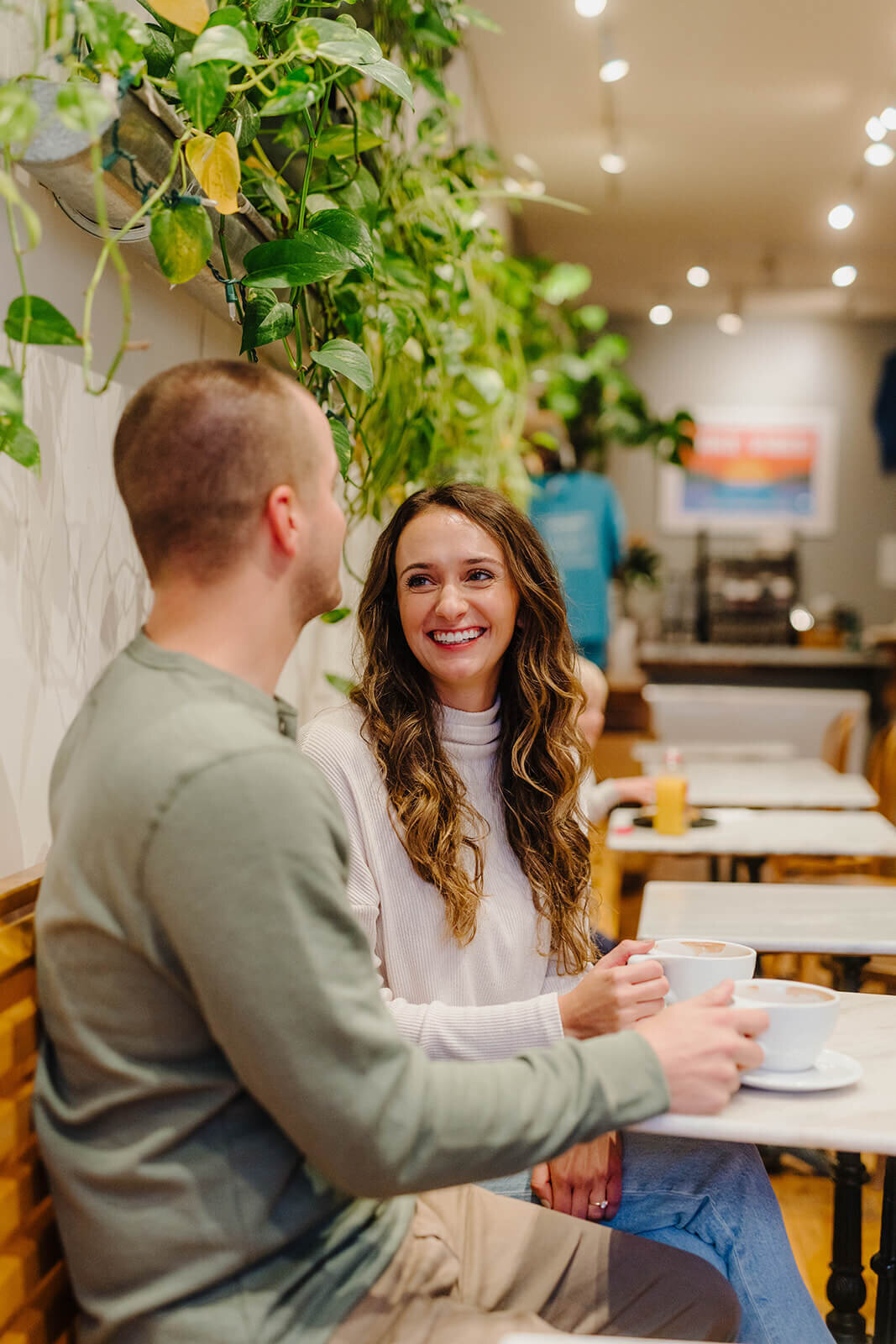 Couple sat at table with coffee at Finger Lakes engagement session