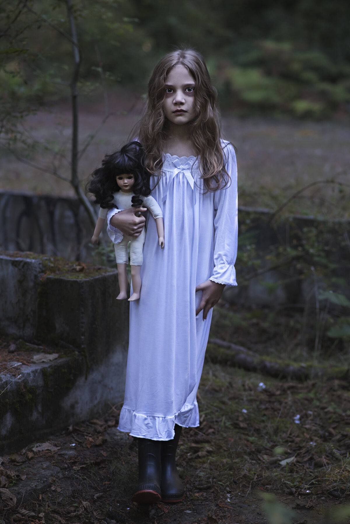 Little ghost girl standing with her doll