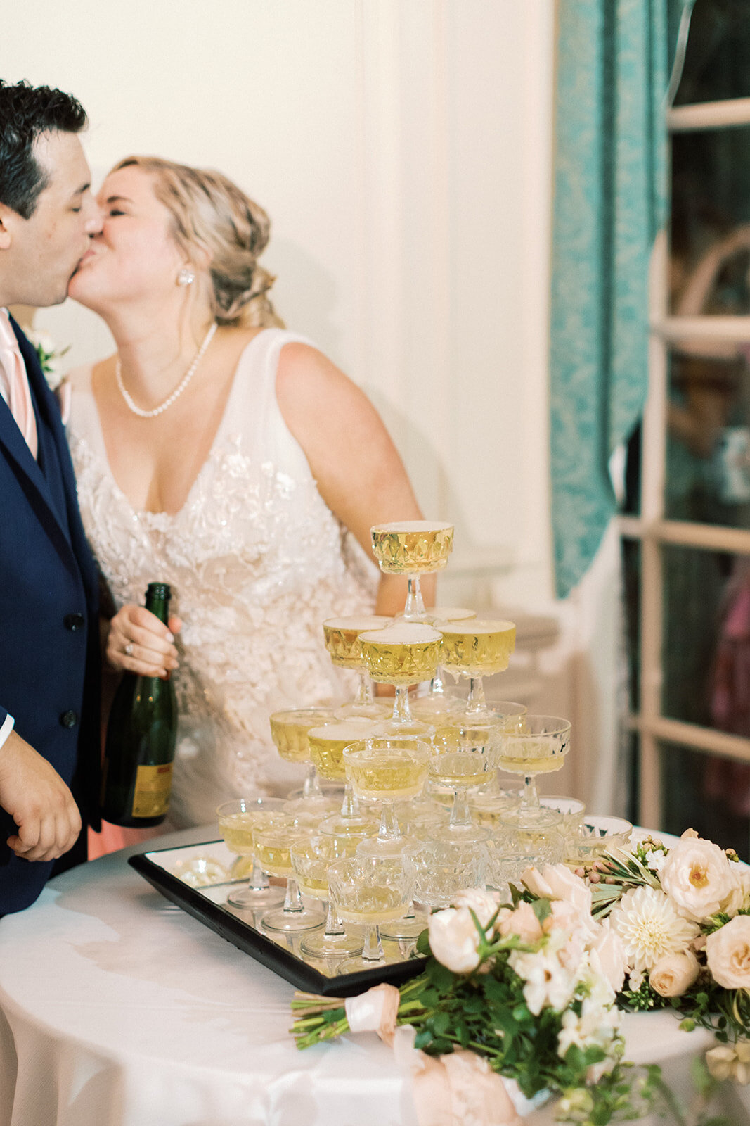 Newlyweds Kissing by Champagne Tower