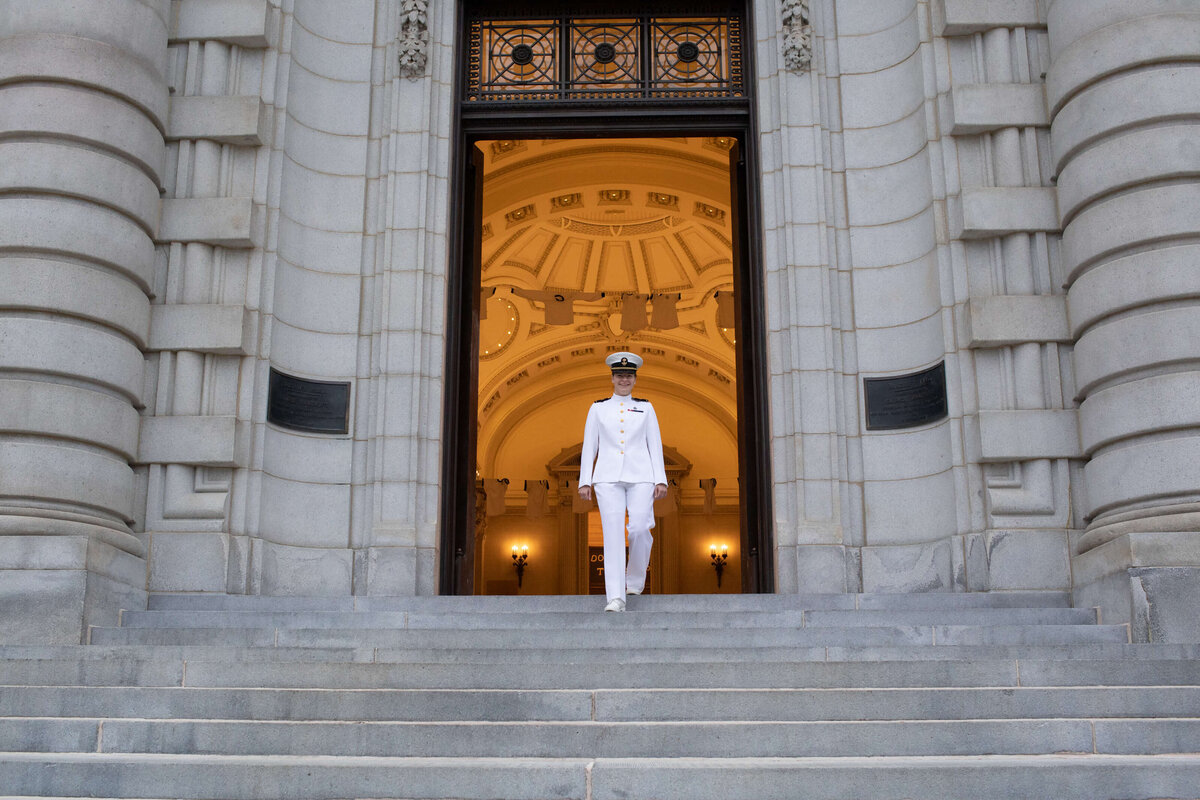 Naval Academy graduate walks steps of  Bancroft Hall.