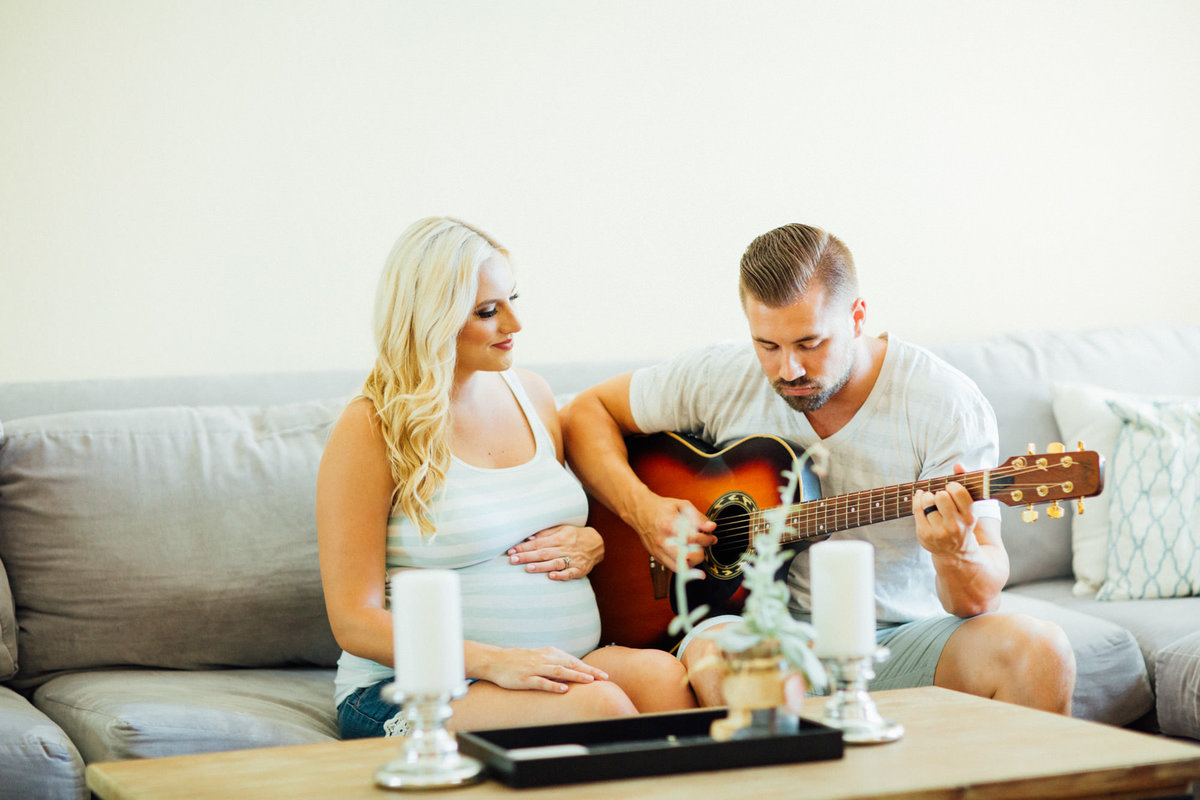 Dad to be plays guitar to his his pregnant Wife and unborn child during a maternity session at their home