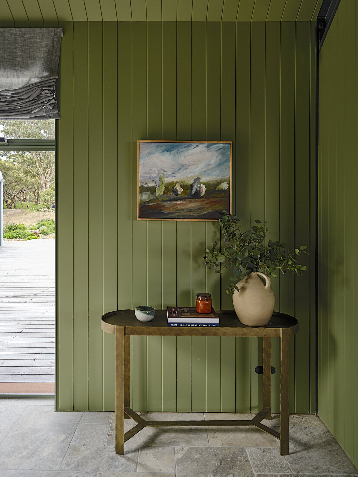 Vignette featuring console table, stone floor tiles and landscape artwork in regional home by Melbourne interior decorator Lisa Hunter.