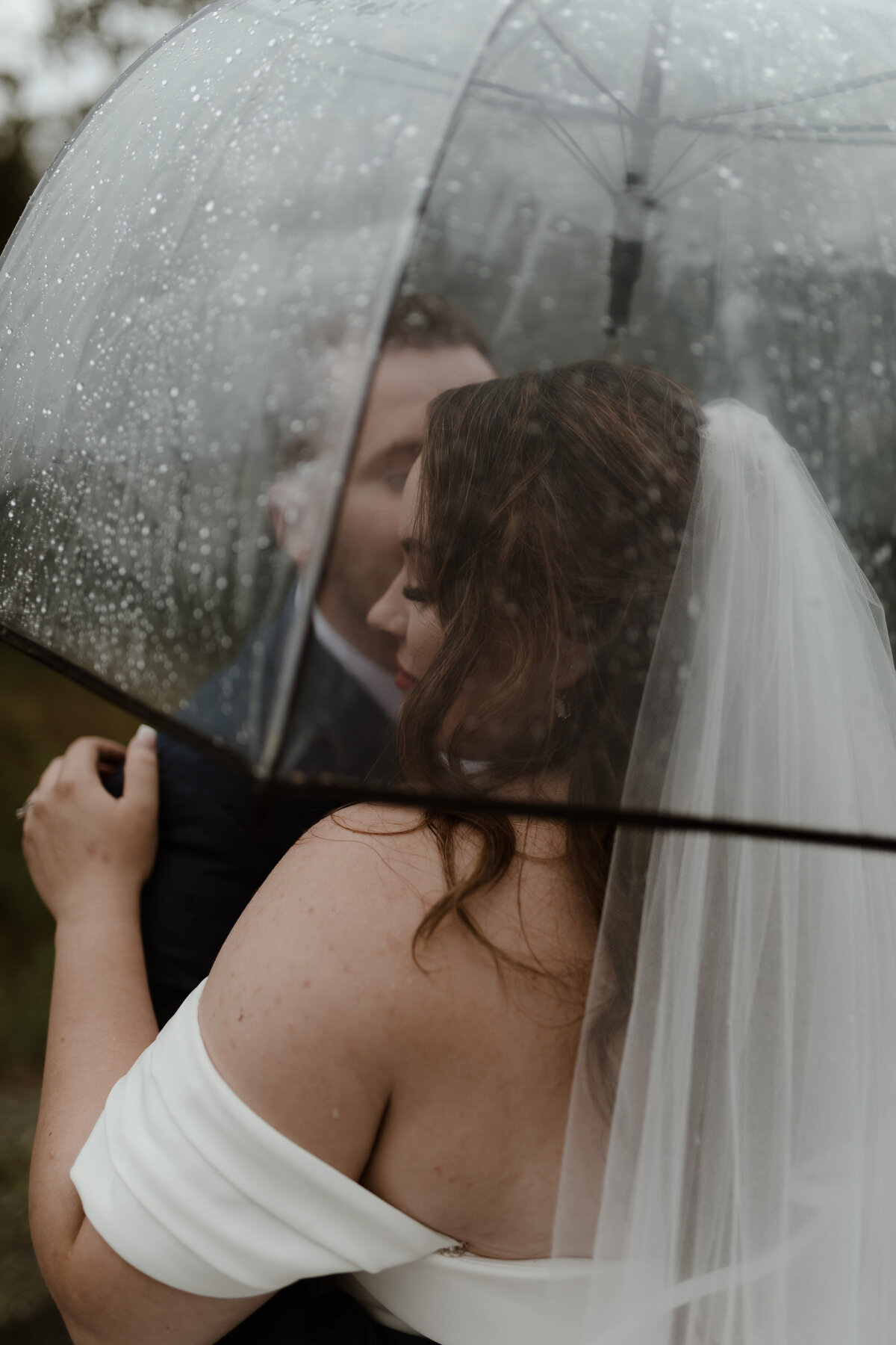 Bride and groom under umbrella