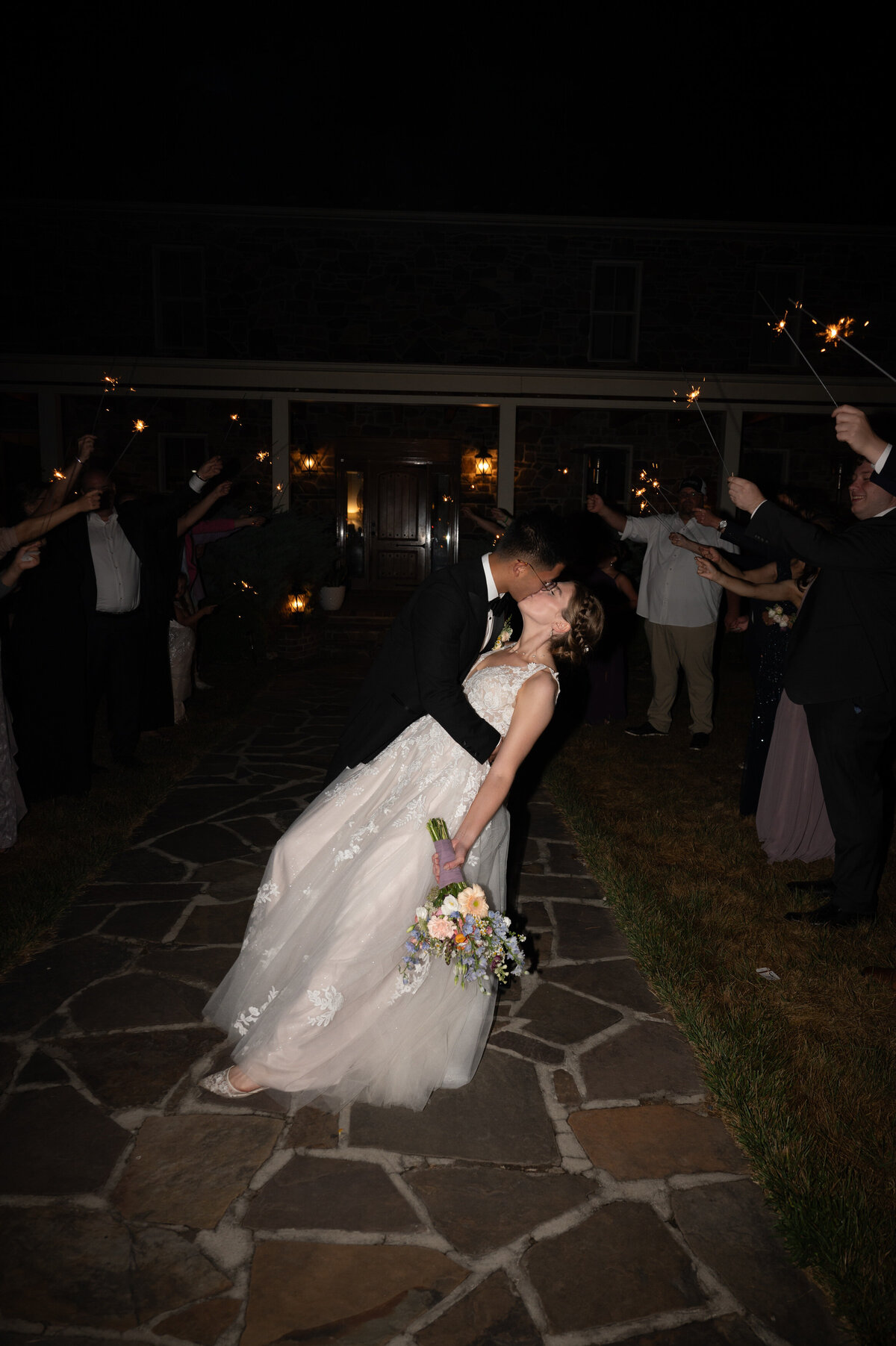 A groom dipping a bride and kissing them