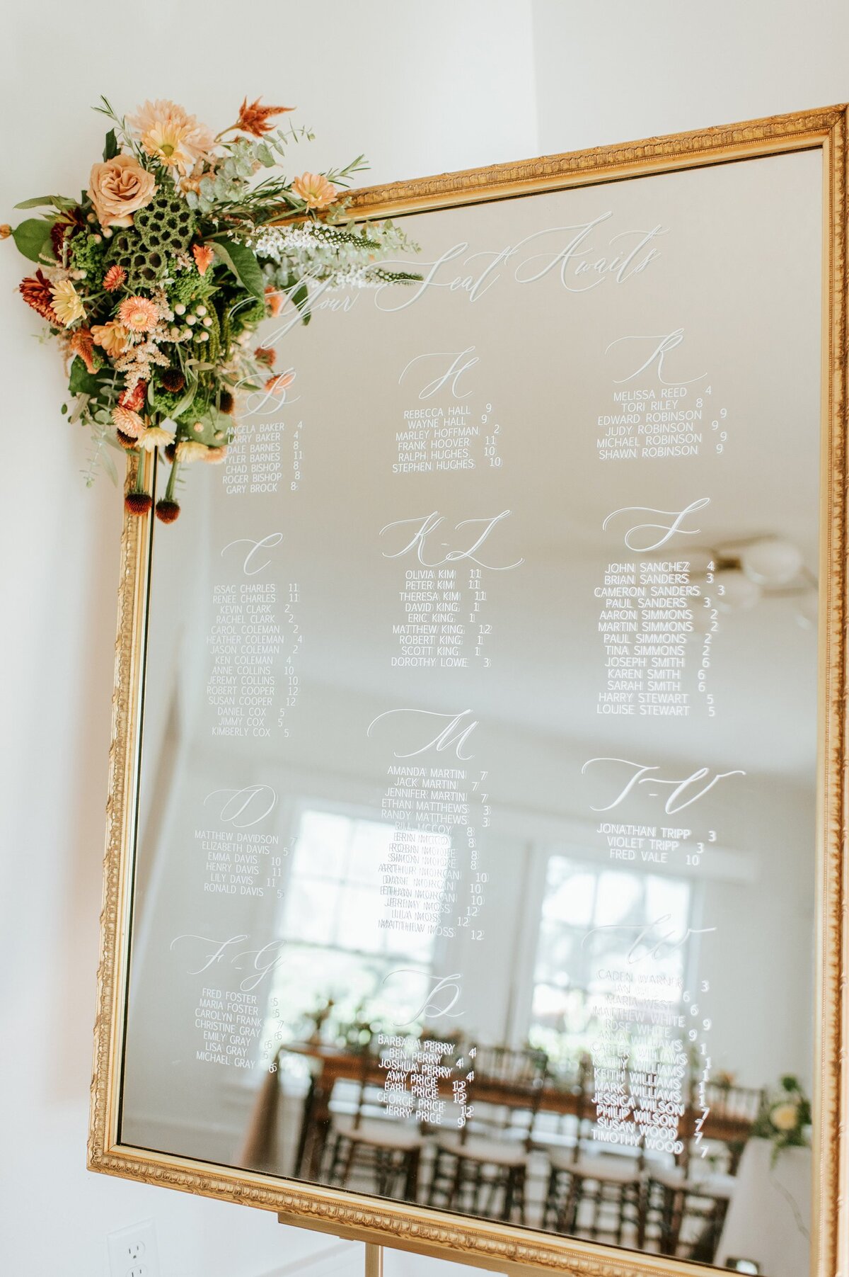 Large gold mirror with ornate border with calligraphy for seating chart