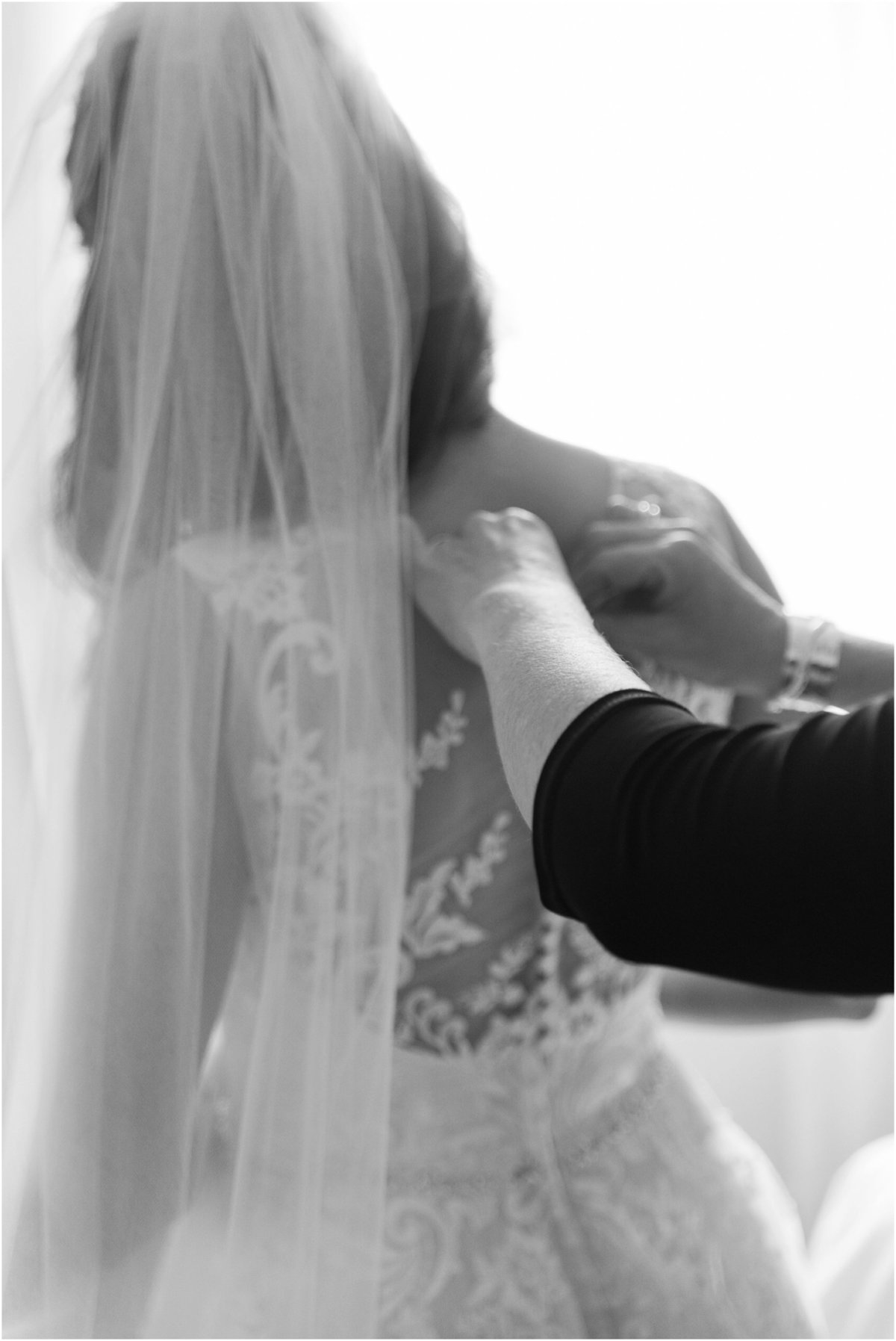 Mother helping bride into her dress