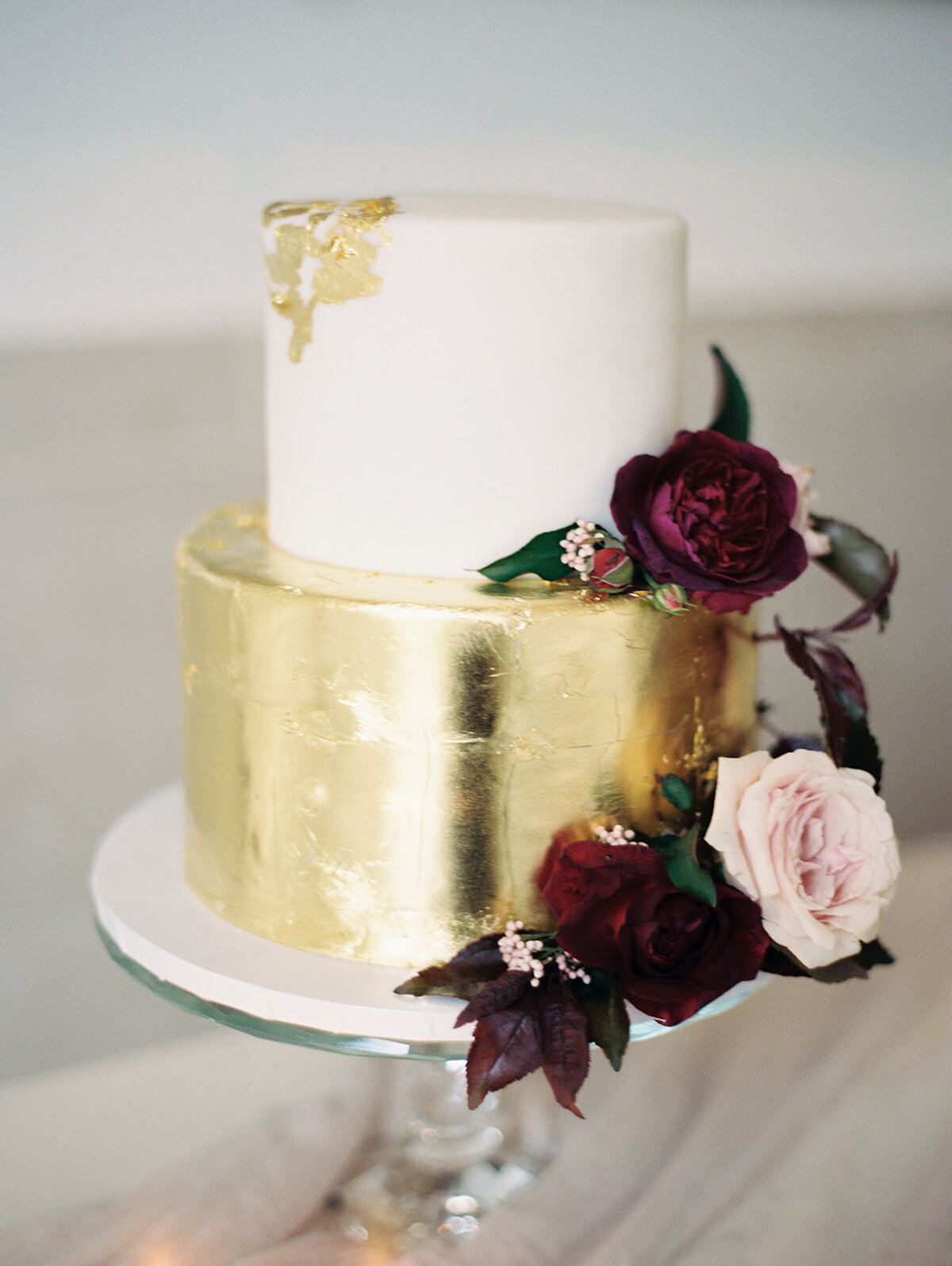 gold foil wedding cake with burgundy flowers