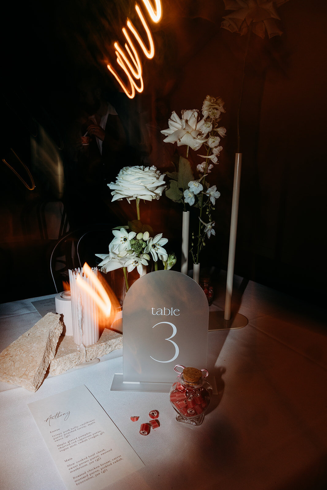 Table decor and acrylic table numbers captured after dark at a wedding at Brindabella Hills Winery