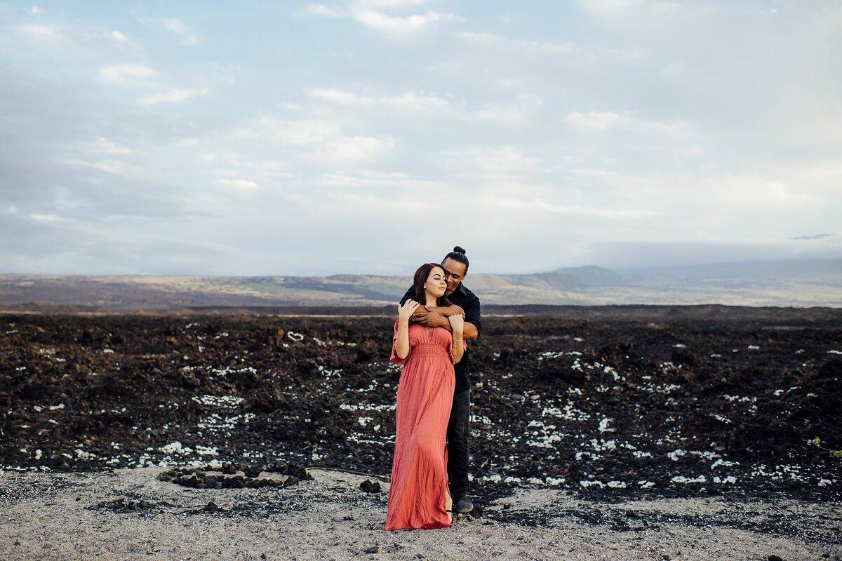 couple standing in front of lava field