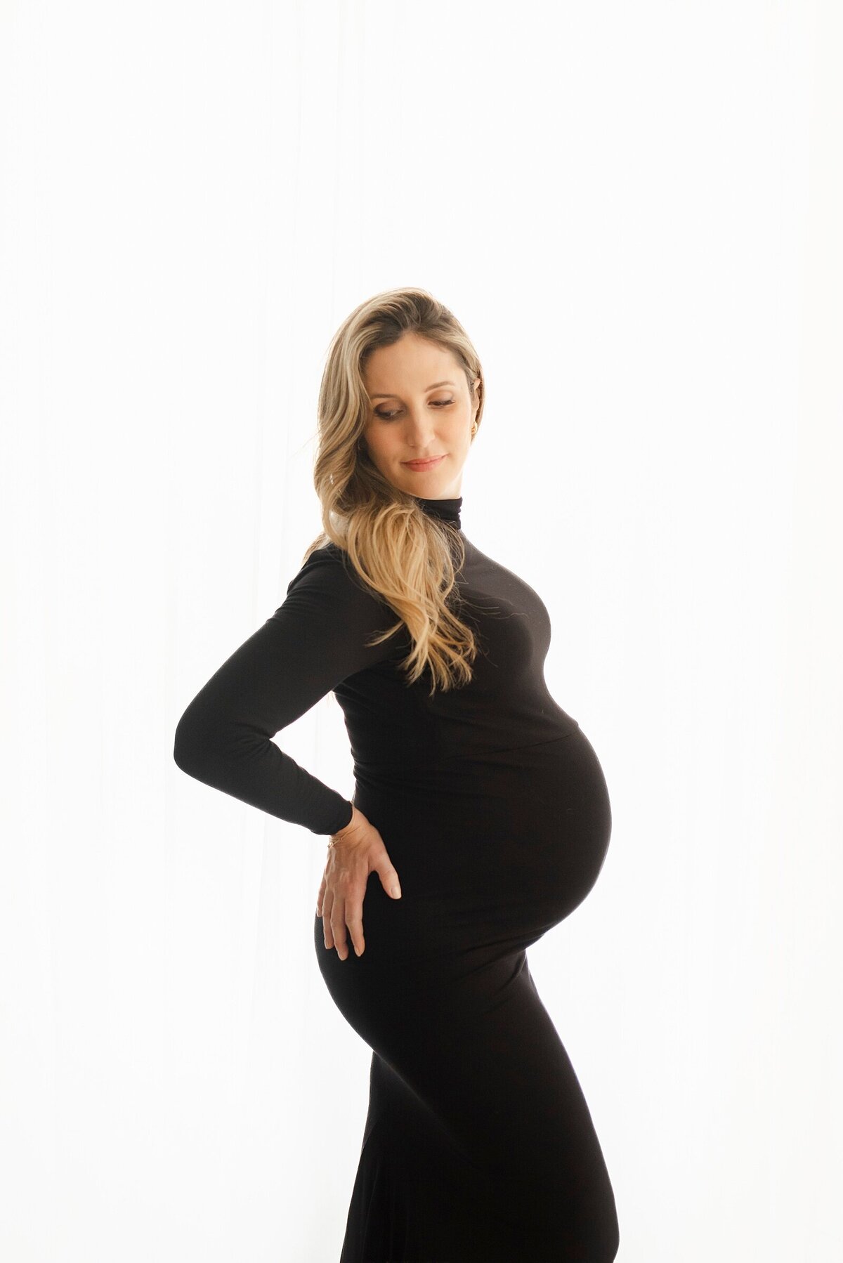 pregnant mom wearing black posing for maternity photography boston