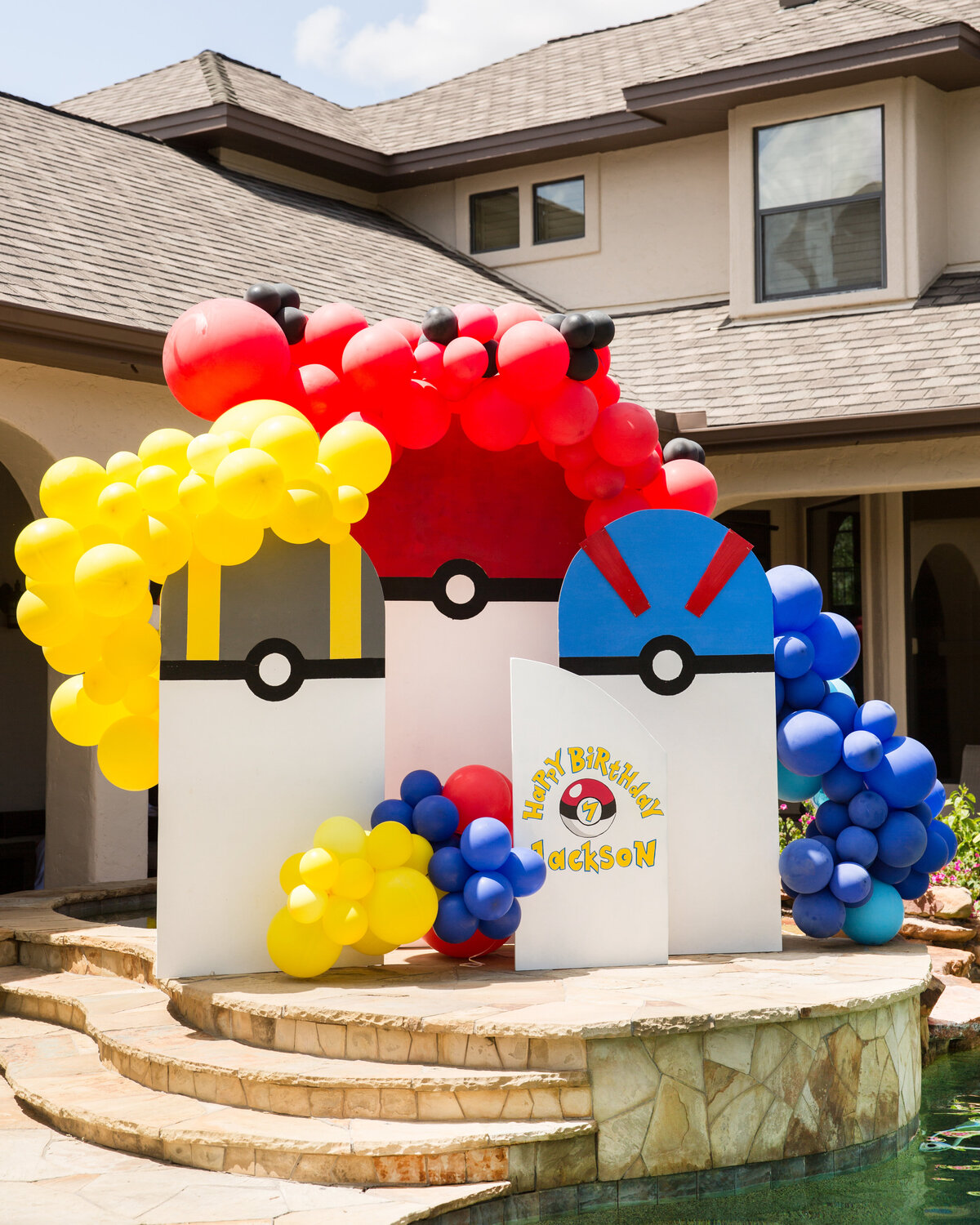 Pokemon themed childrens birthday arch backdrop design with primary colored balloon arches