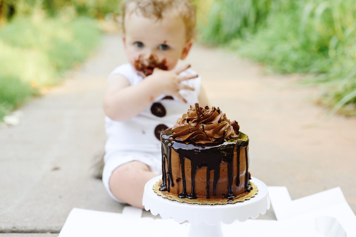 Boy in white with chocolate cake face