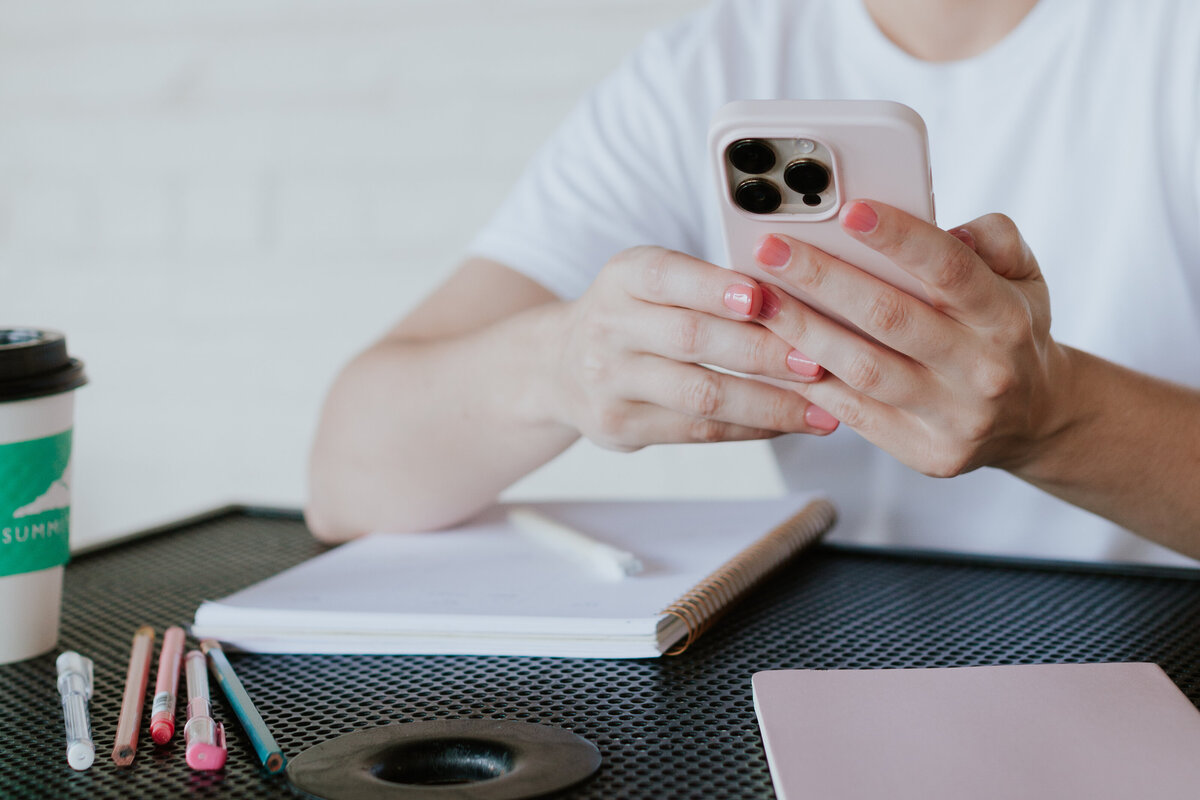 woman-with-phone-and-office-supplies-working-from-coffee-shop-for-brand-session-villa-heights-charlotte
