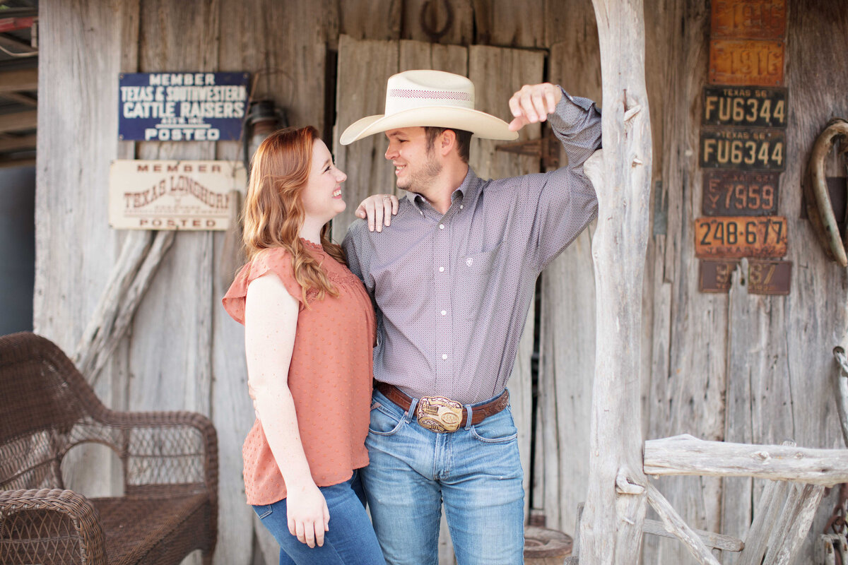 engagement session at Boerne wedding venue peach top red hair cowboy hat and old wood building by Firefly Photography