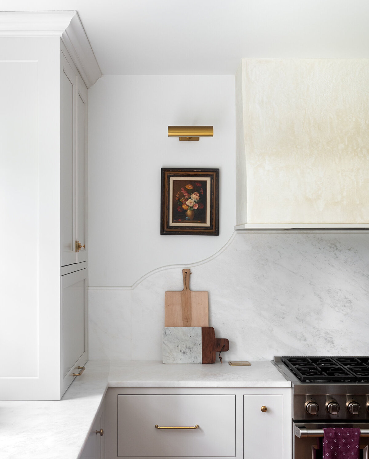 white cabinets with chopping board and stove top 
