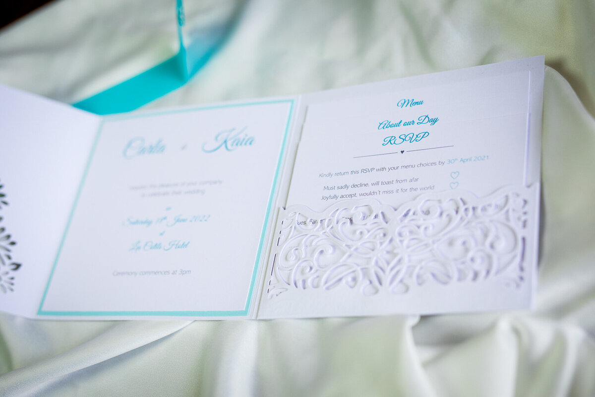 White wedding invitation with turquoise butterfly clasp