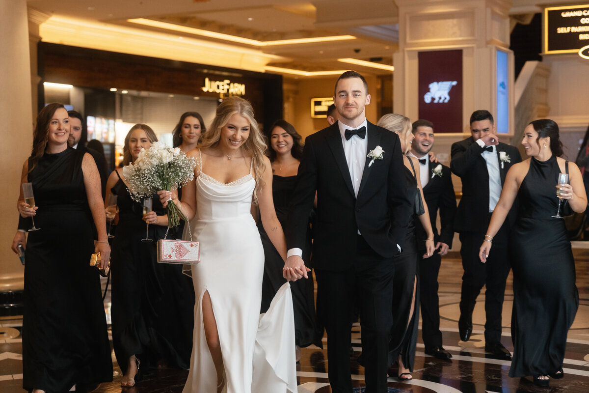 bride and groom walk with their friends after their wedding 