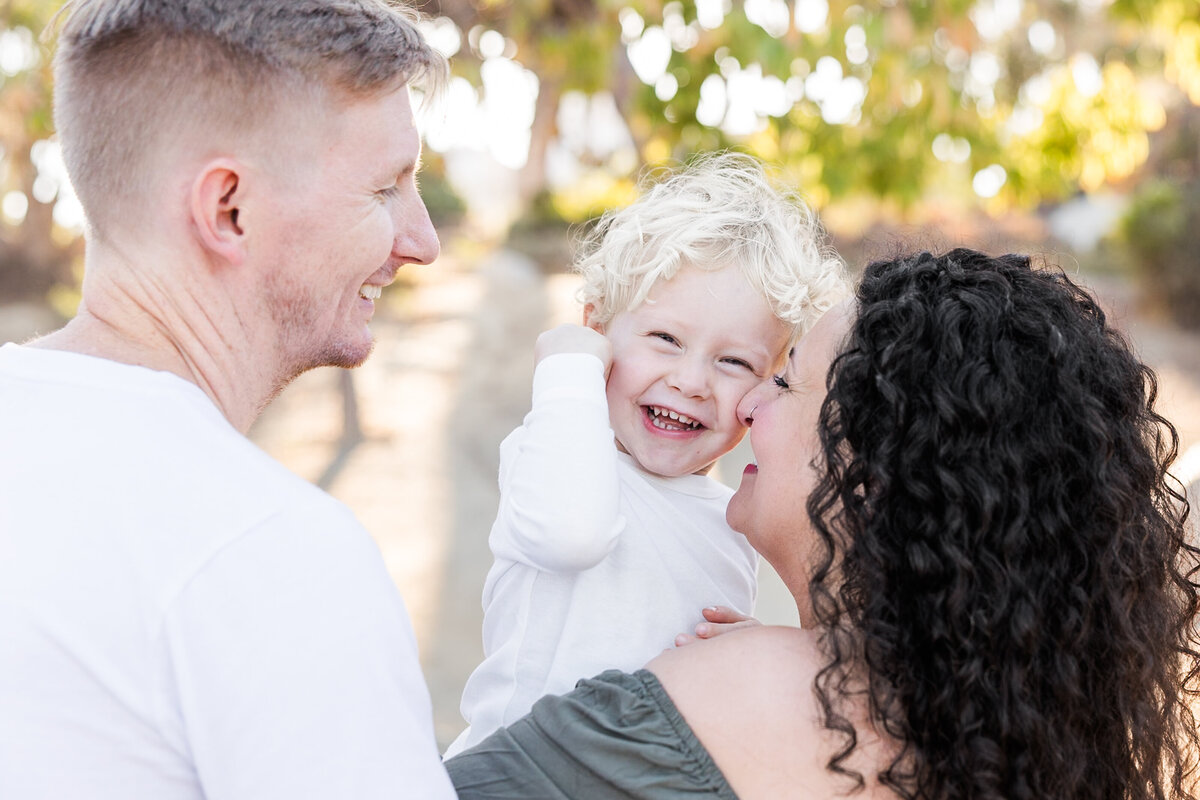 parents holding son and laughing san diego