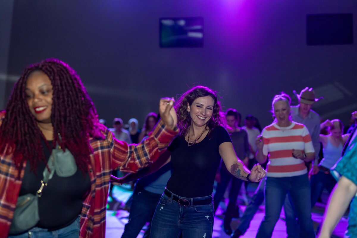 two women dancing and smiling