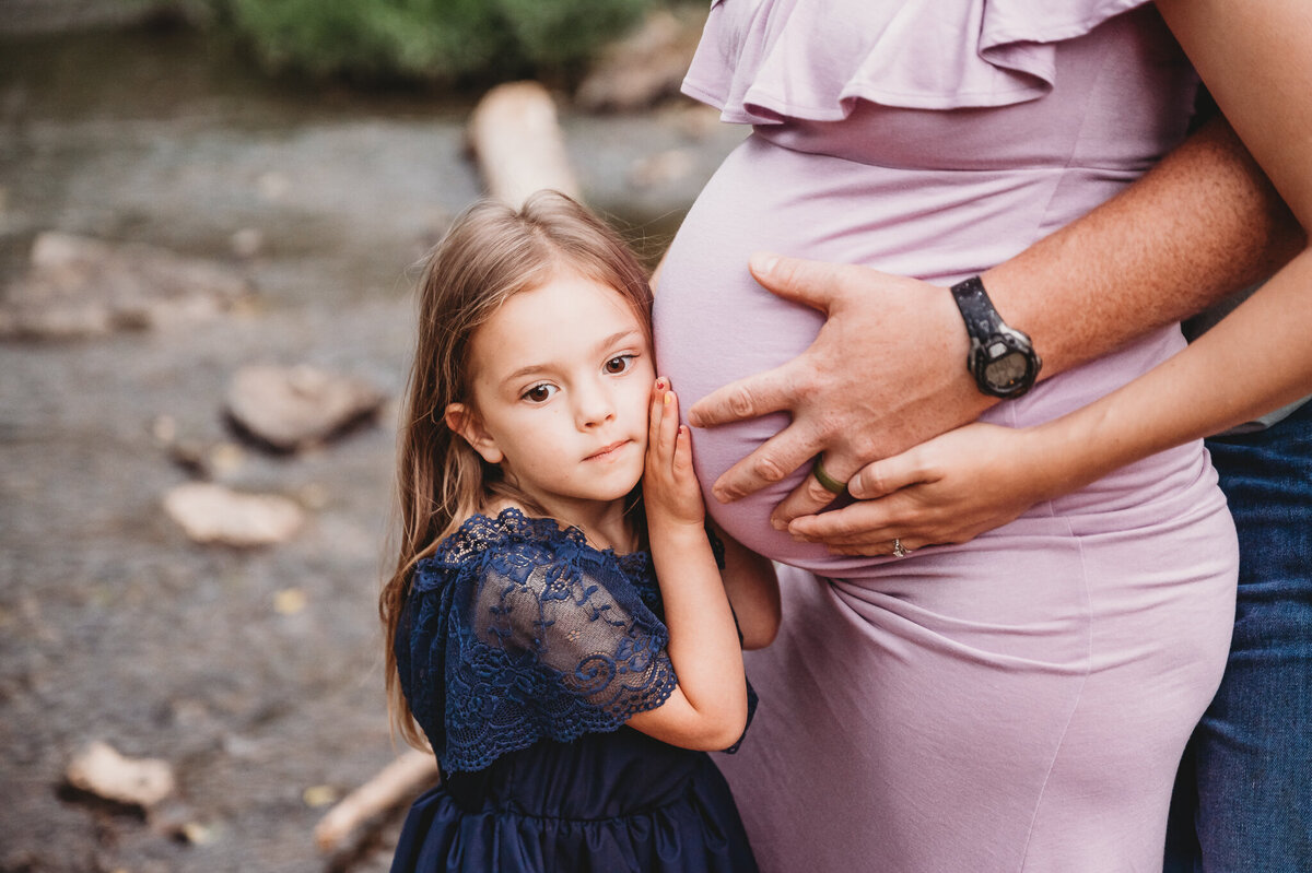 Daughter listening to mother's pregnant belly