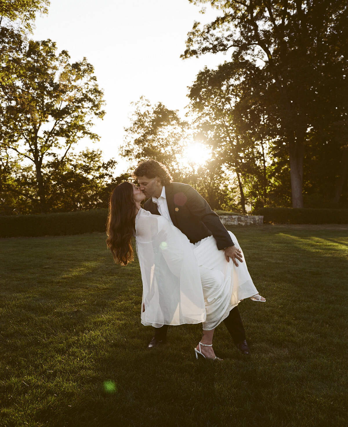Couple goes for a dip in golden hour sunset lighting at their rehearsal at Boscobel House & Gardens