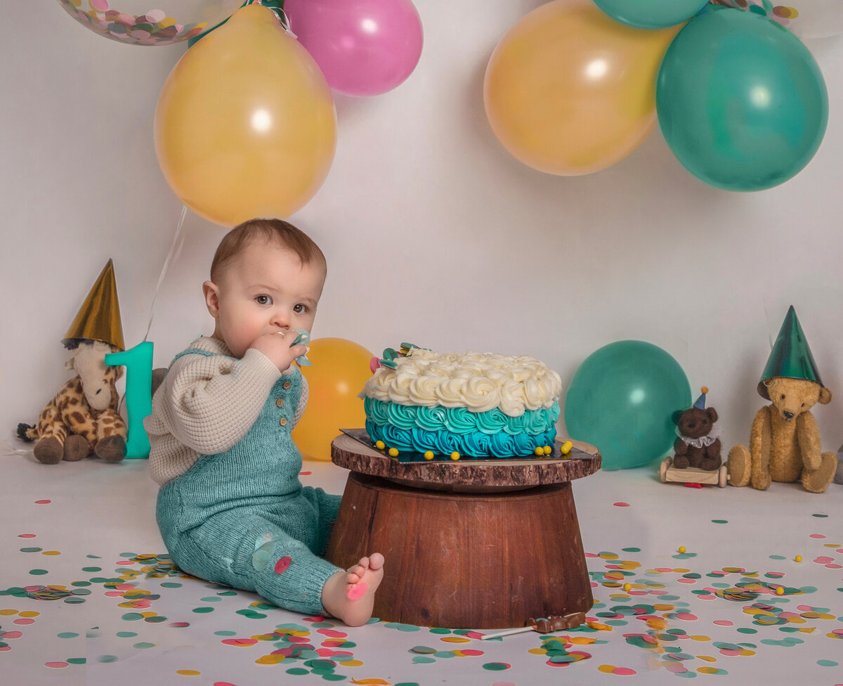 Smiling baby boy during cake smash session with custom theme – First birthday photos in Ottawa