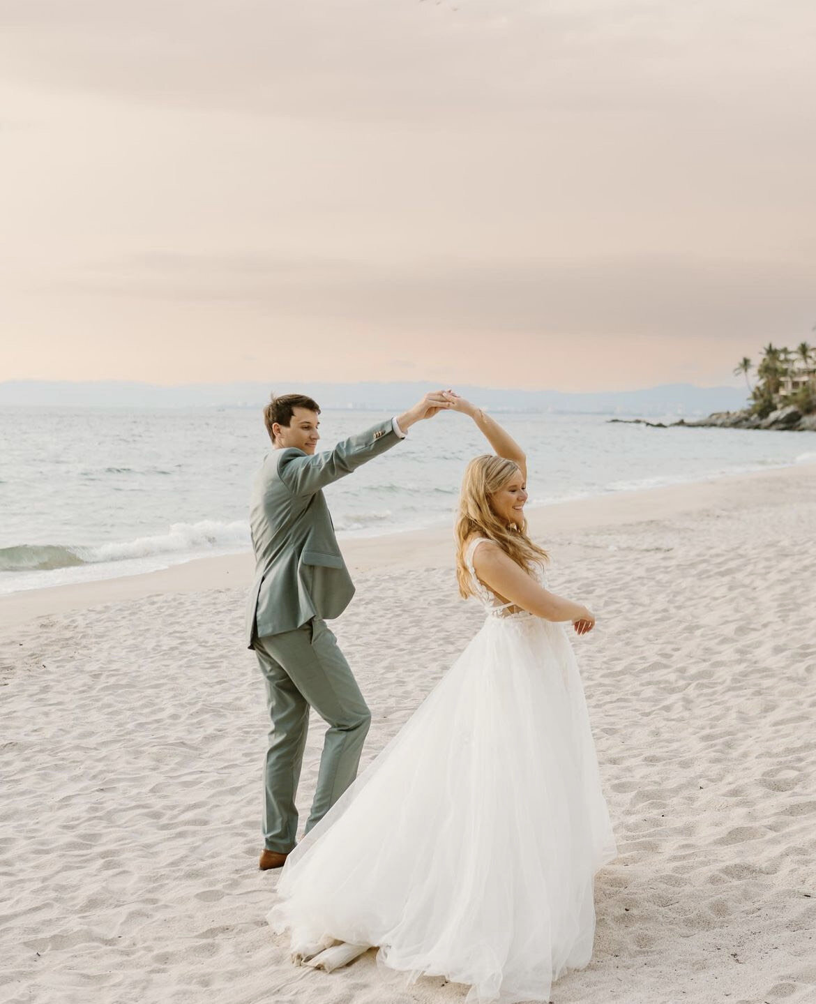 Bride and groom share a romantic dance on the beach at sunset, with the bride’s look styled by a wedding mobile hair and makeup team for a seamless destination wedding experience.