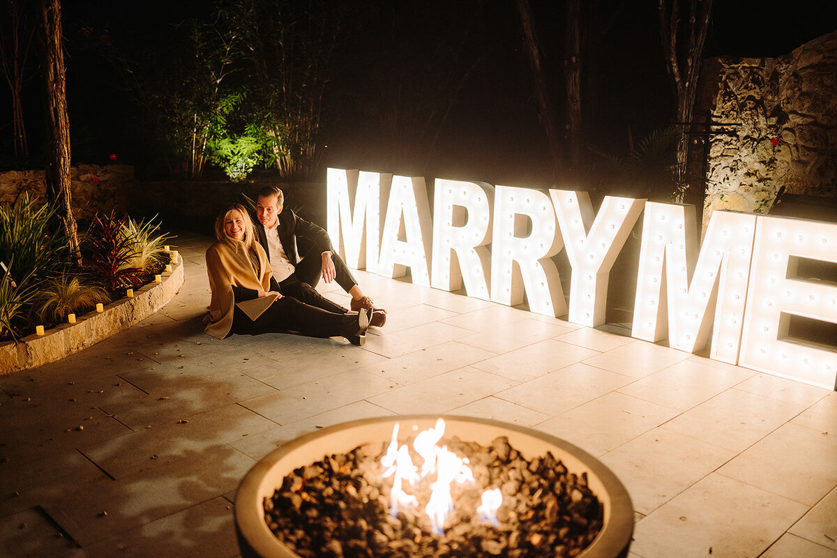 How to propose Austin couple sitting next to fire and marry me marquee