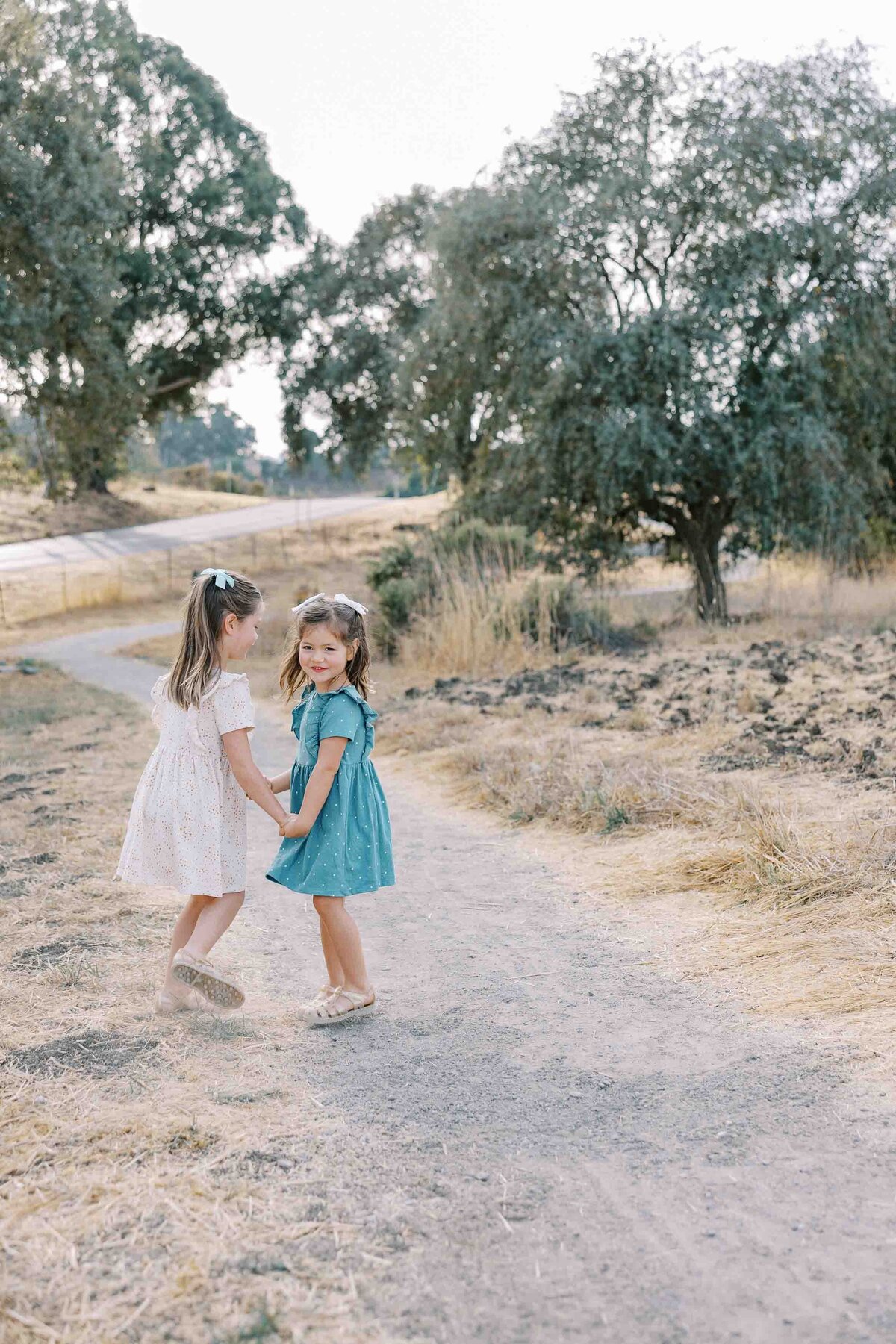 sisters wearing dresses and bows in their hair and dancing