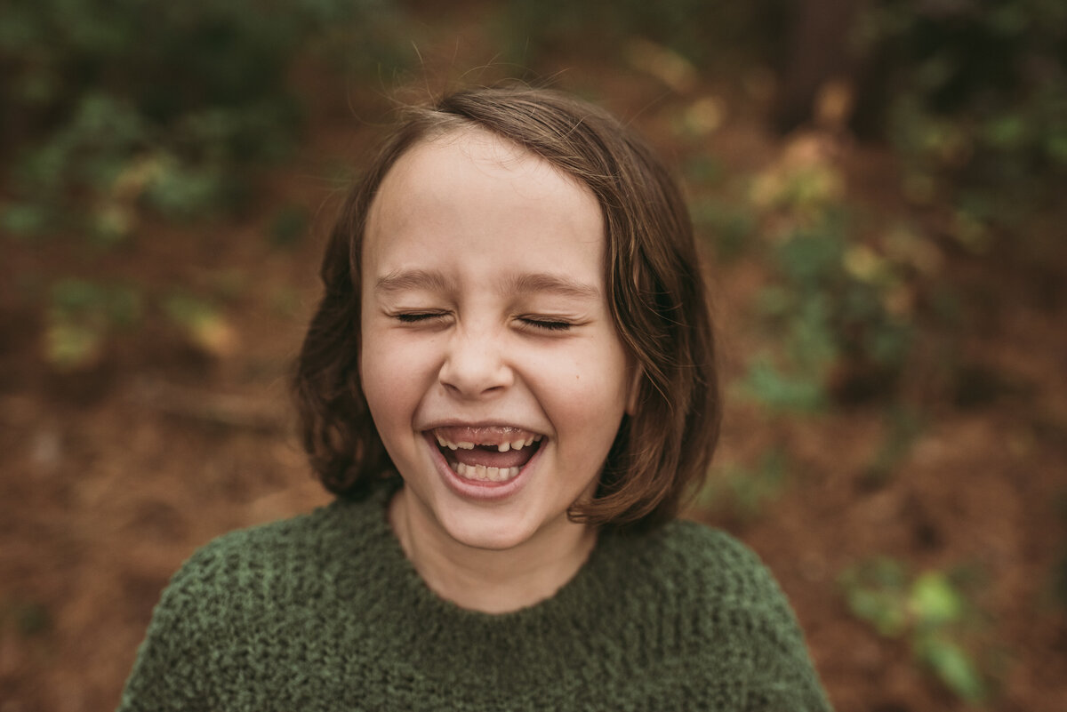 young girl laughing missing teeth