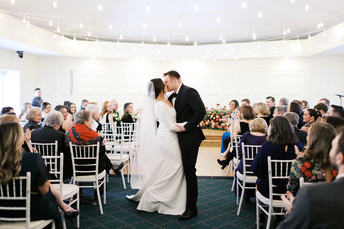 Just married husband and wife kissing at St. Paul College Club at the wedding ceremony