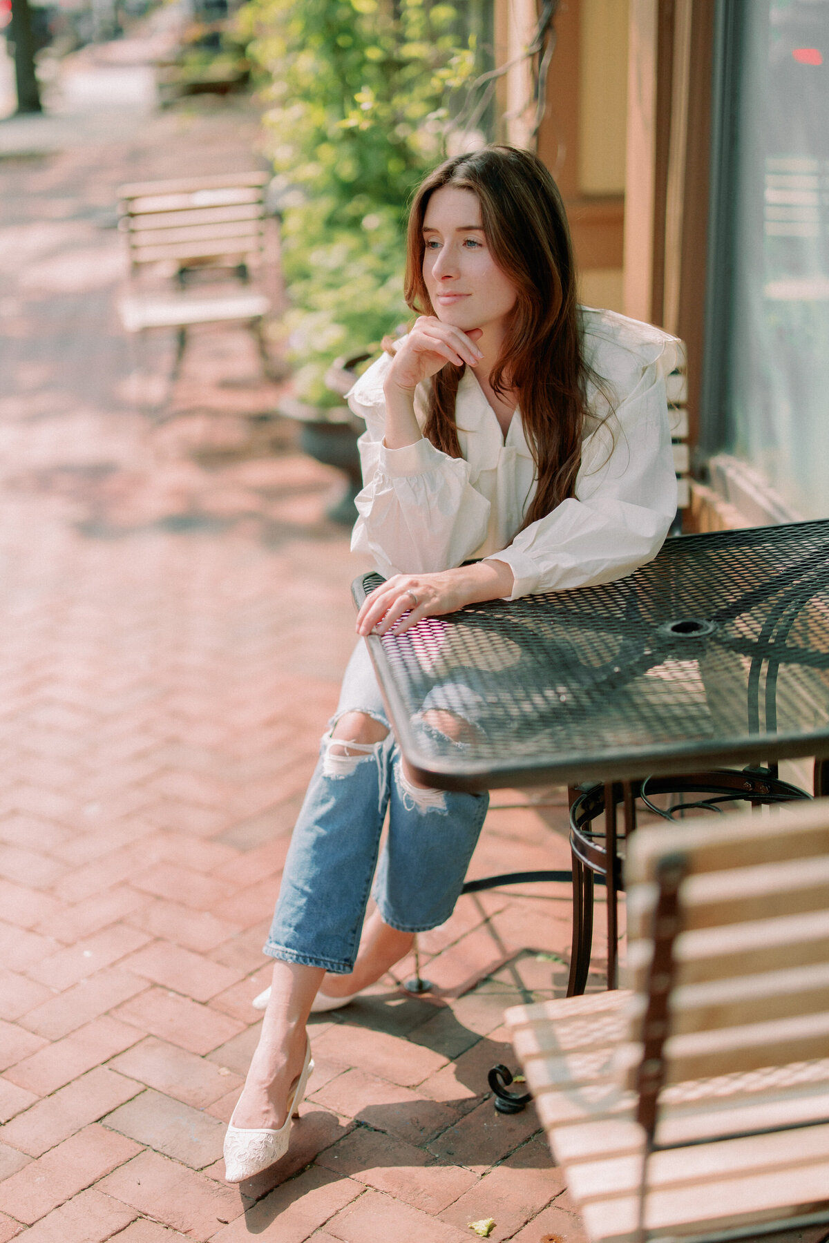 A person leans against a table, looking out to the distance.