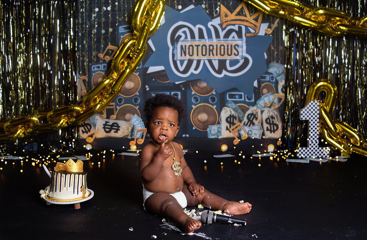 Baby boy sitting next to a cake being captured during cake smash photoshoot with Franklin, Tennessee family photographer