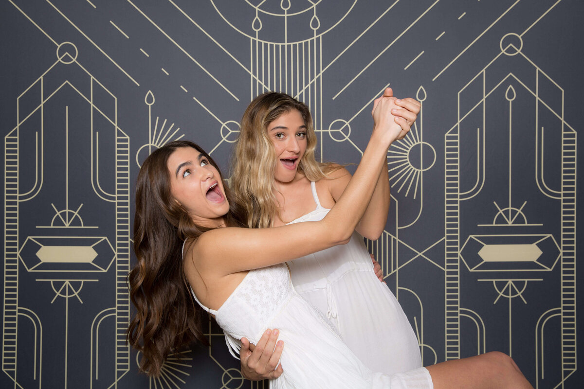 two ladies having fun, dancing like pose for a photo booth