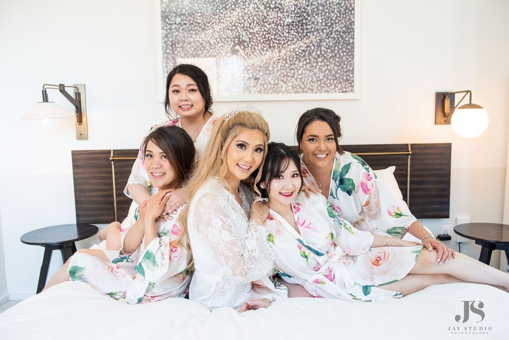 Bride poses with her bridesmaids in pink flowered robes at the Halcyon Hotel in Cherry Creek , Colorado.