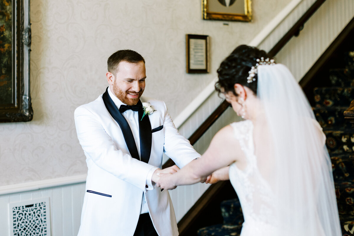 groom looking at her dress in awe