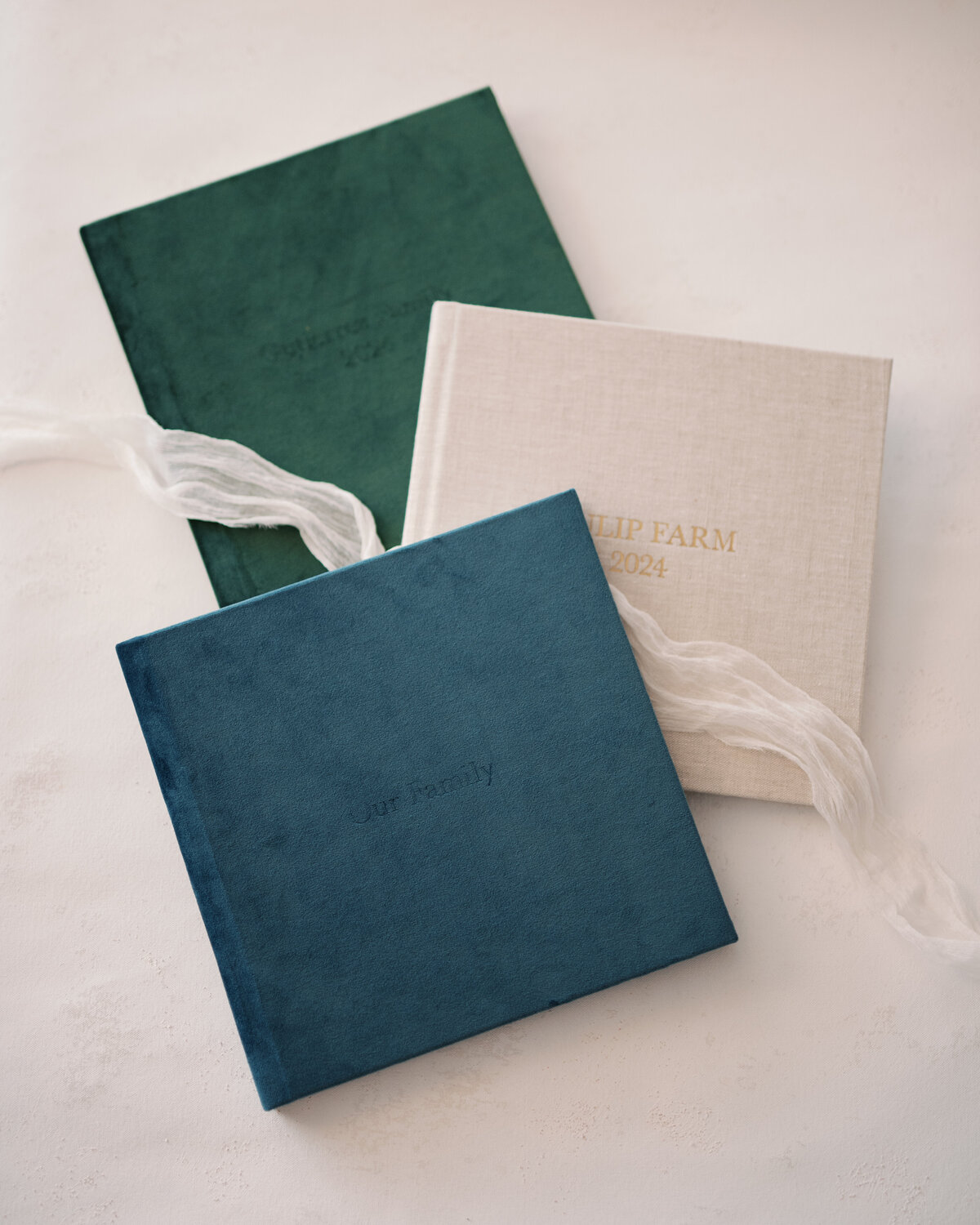 stack of linen and velvet albums with silk ribbon decoration