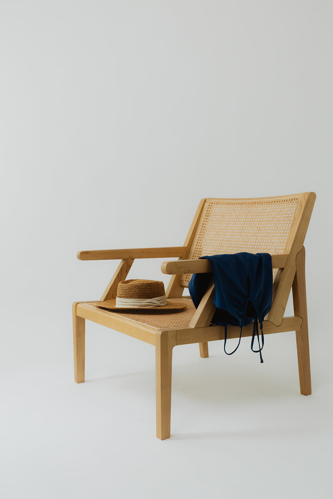 sustainable swimwear laying on a chair with a summer hat