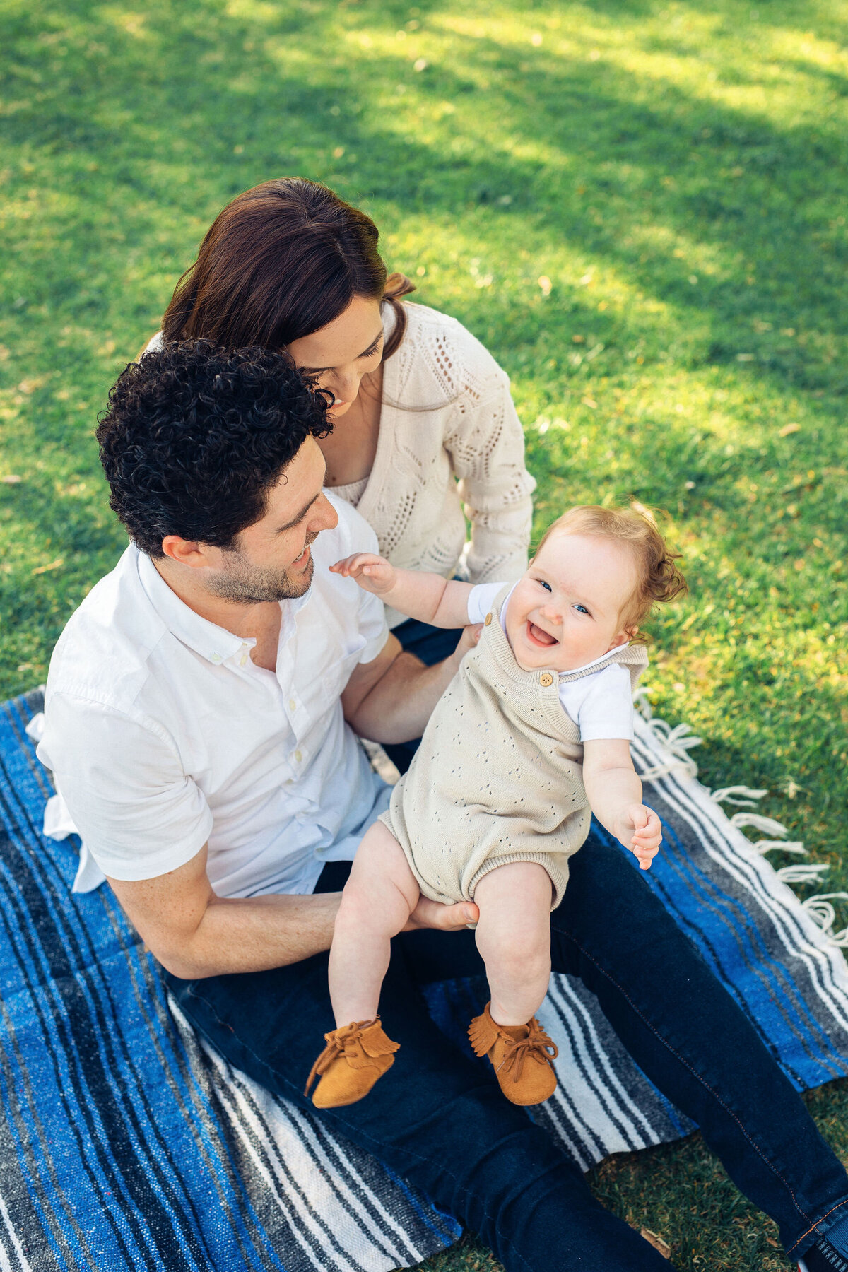 Family Portrait Photo Of Couple Holding Their Baby While Sitting On The Ground Los Angeles