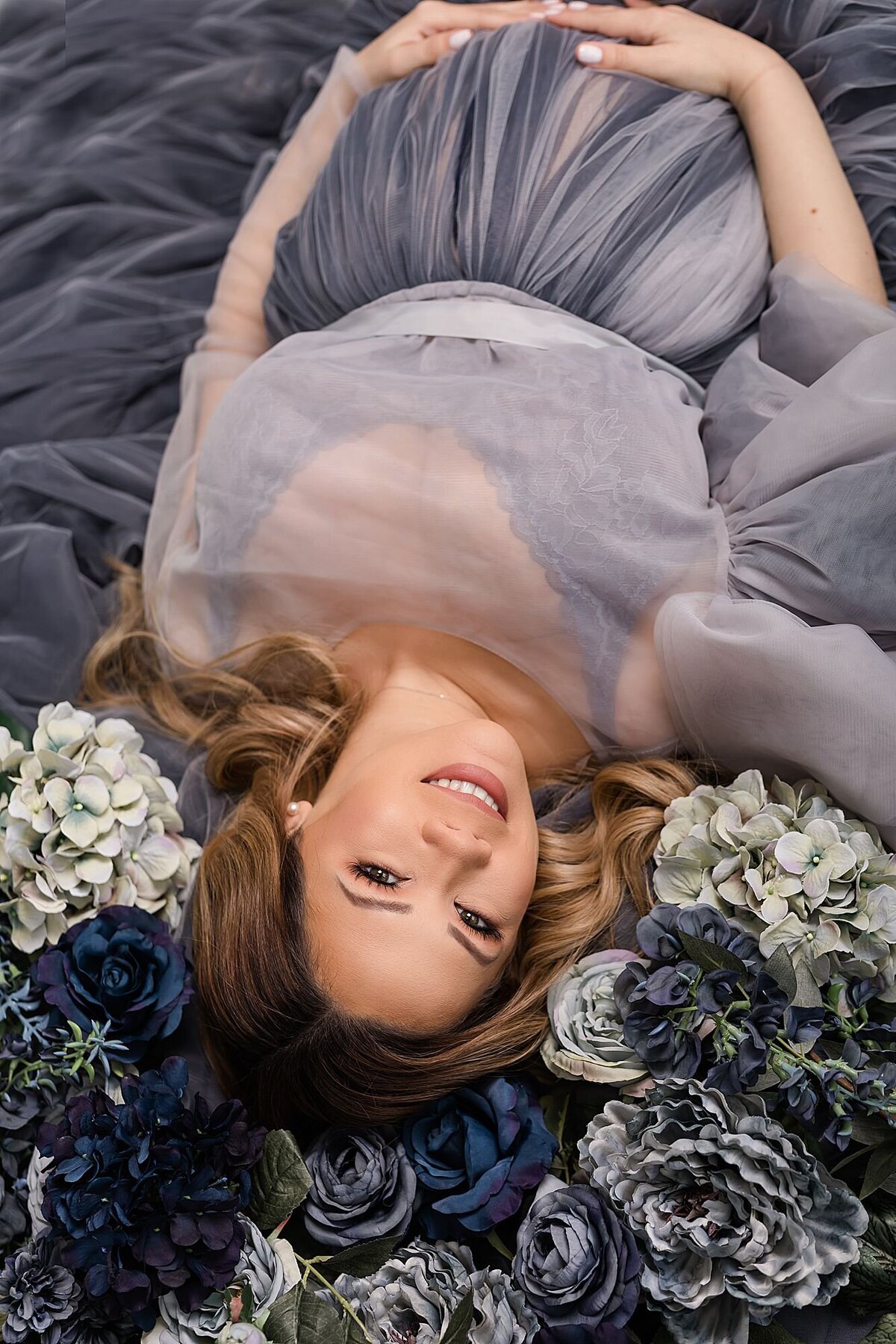 studio maternity photographs in Orlando floral laying down