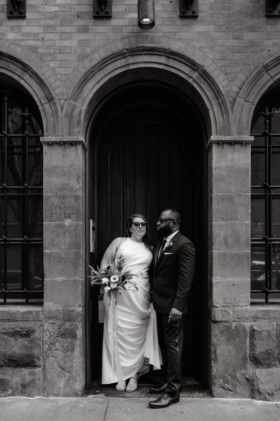 Black and white photo of the bride and the groom in front of 11 Spring Street, New York City.
