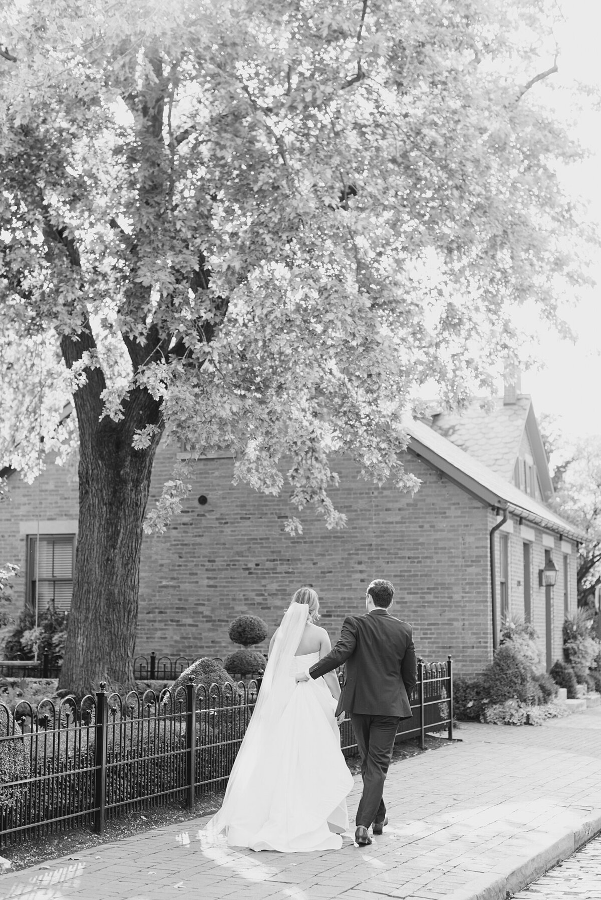 Groom holds bride's dress walking to wedding at The Westin in Columbus, Ohio