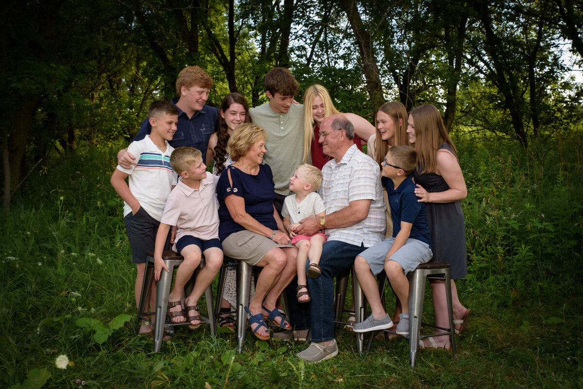 Large extended family portrait with grandparents and their grandchildren sitting in grassy area at Fonferek Glen County Park near Green Bay, Wisconsin