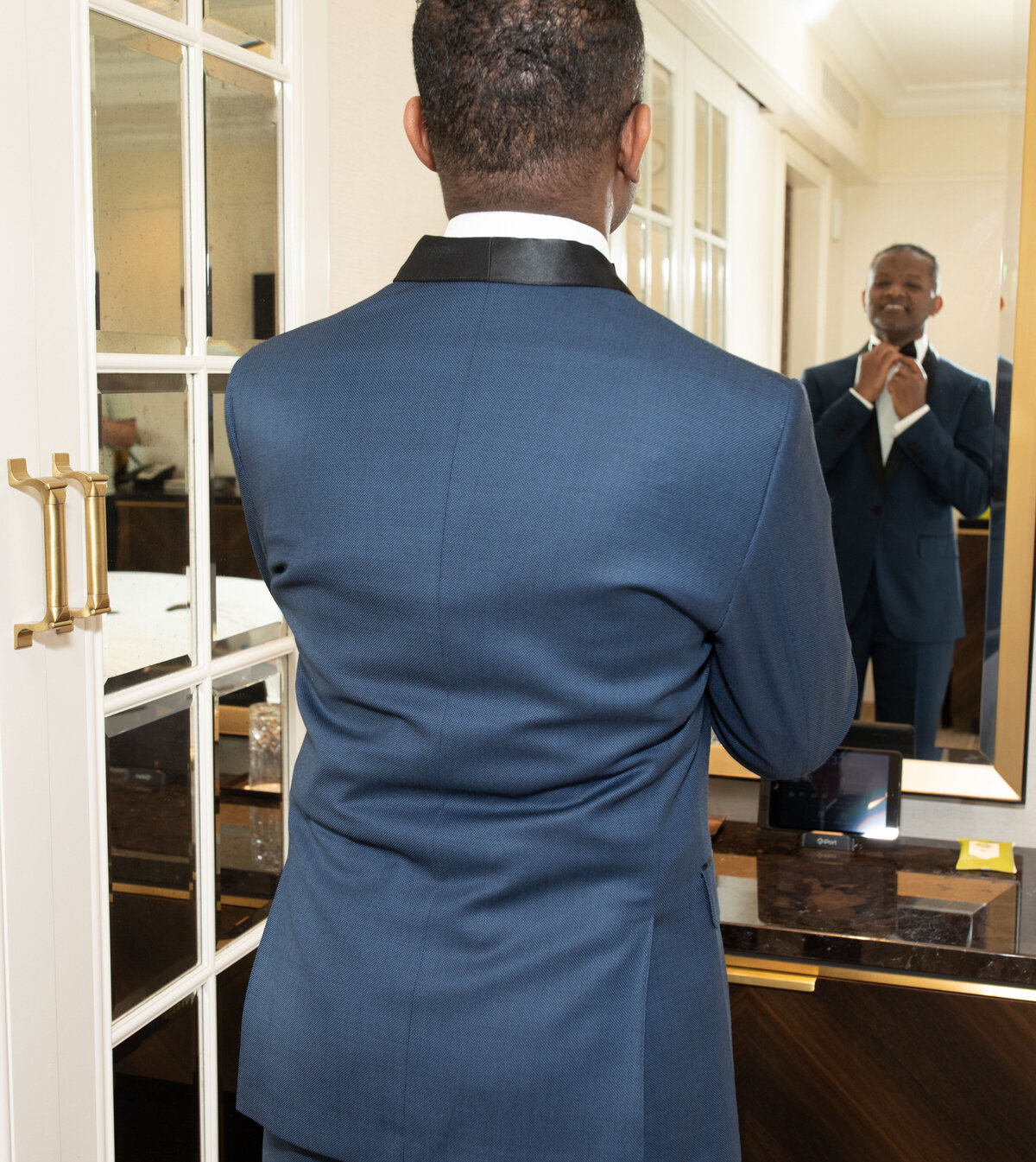 st-regis-atlanta-wedding-groom-adjusting-bow-tie-in-mirror