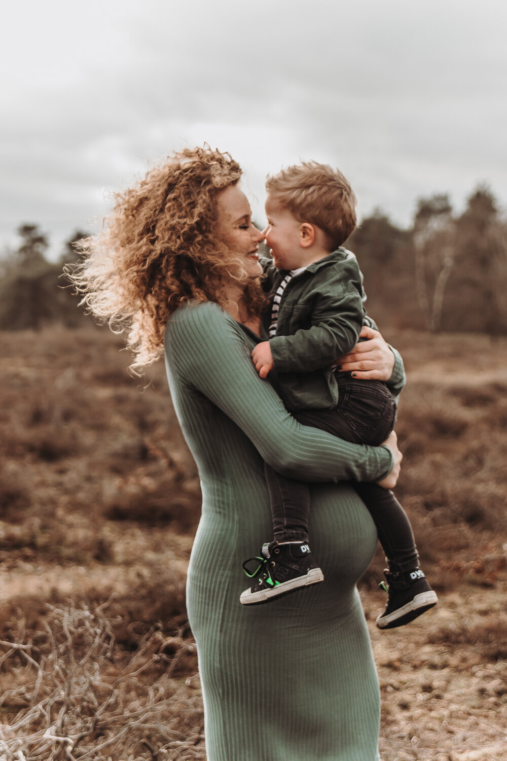 Vrouw zwanger met zoon lachend