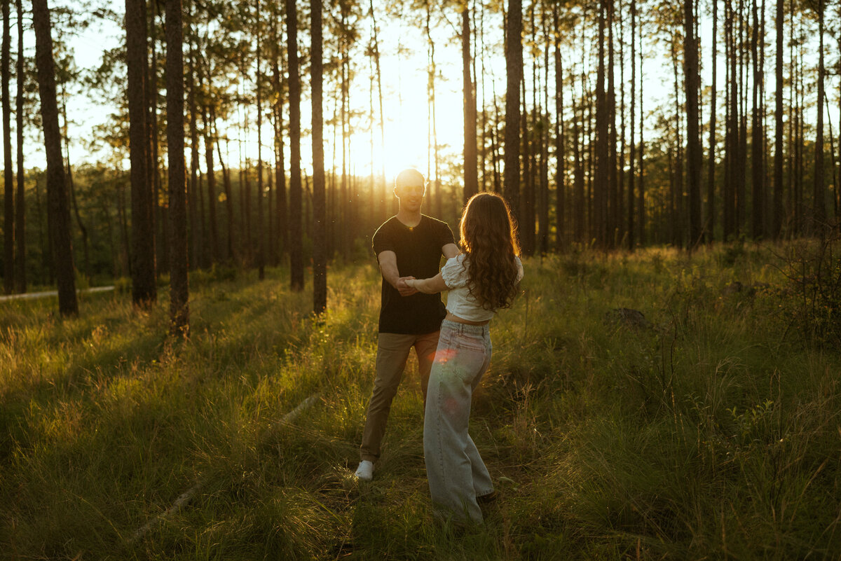 Couple posing for portraits in a forest.